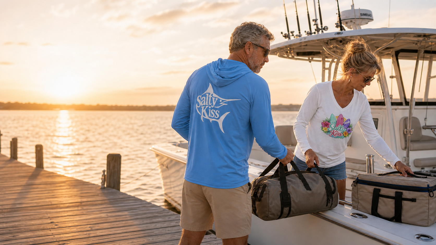 Man and woman wearing Salty Kiss performance and coastal graphic shirts while packing a boat for a day on the water.